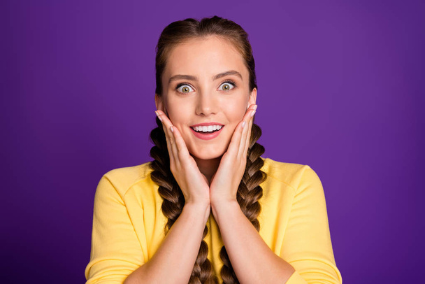 Closeup photo of amazing lady long braids holding arms on cheekbones listen good news discounts final period wear casual yellow jumper isolated purple color background - Fotó, kép