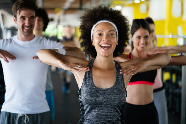 Grupa szczęśliwych, dopasowanych przyjaciół ćwiczących razem na siłowni - Zdjęcie, obraz