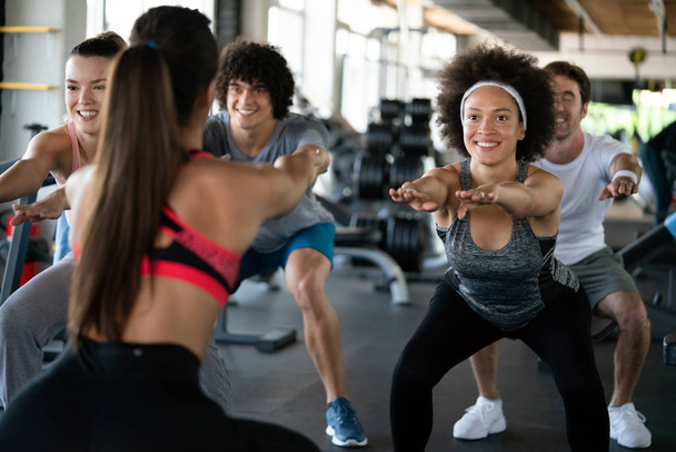 Group of fit young people at the gym exercising - Фото, изображение