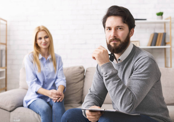 Confident therapist sitting with assistant in private office - Photo, Image