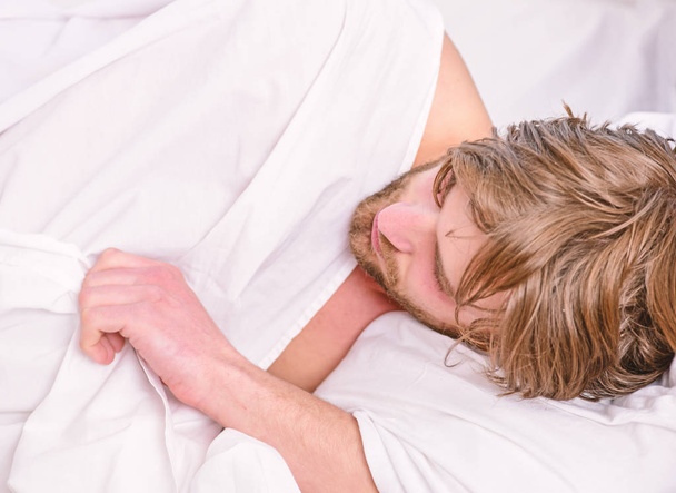 Ο εύθυμος νεαρός ξυπνάει μετά τον ύπνο το πρωί. Γυμνά πόδια ενός άντρα που κρυφοκοιτάζει έξω από τον όρμο. Κορυφαία θέα του σέξι μυών νεαρό άντρα που κοιμάται στο κρεβάτι. - Φωτογραφία, εικόνα