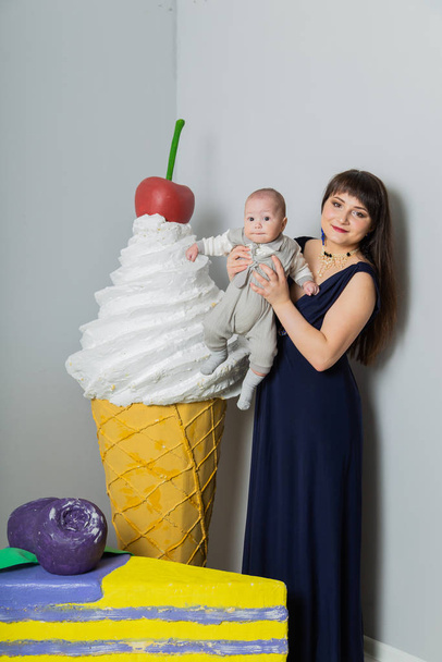 Happy mother in evening dress with a child in a photo studio. - Fotografie, Obrázek