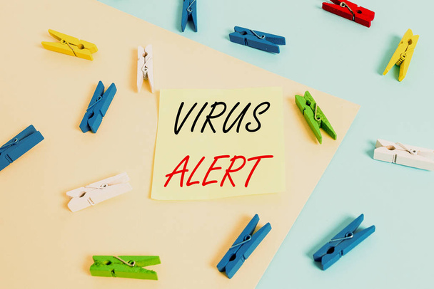 Pisanie tekstu Wirus Alert. Biznesowa koncepcja ostrzegania przed nieistniejącym zagrożeniem wirusem komputerowym Kolorowy papier szpilka pusty przypomnienie żółty niebieski podłoga tło biuro. - Zdjęcie, obraz
