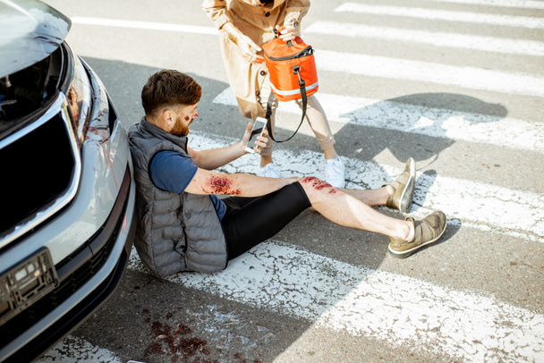 Woman driver with injured man on the road - Valokuva, kuva