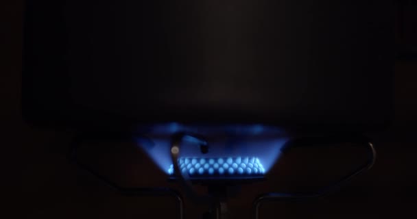 Close-up video shot van blauwe vlam branden in gas-jet donkere achtergrond kopiëren ruimte tekst. Gasbrander licht macro slow motion behang. Begrip "gevaarlijke ecologische alternatieve beschermingseconomie" - Video