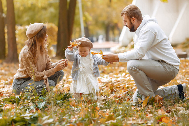 Family with little daughter in a autumn park - Foto, afbeelding