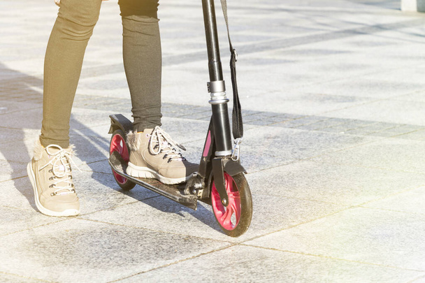 adolescente cavalca uno scooter su un marciapiede della città
. - Foto, immagini