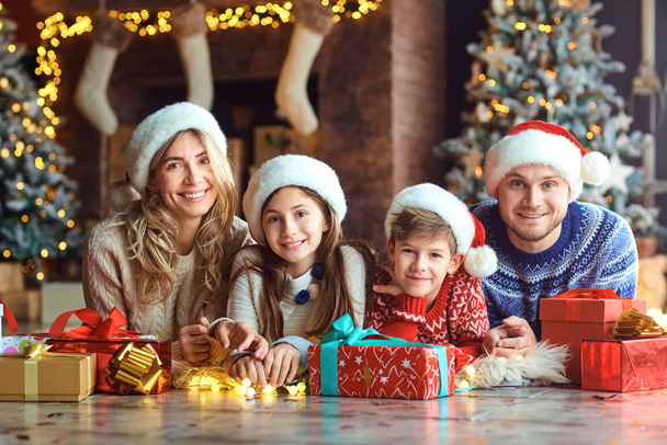 Happy family smiling with gifts in a room at Christmas - Foto, Bild