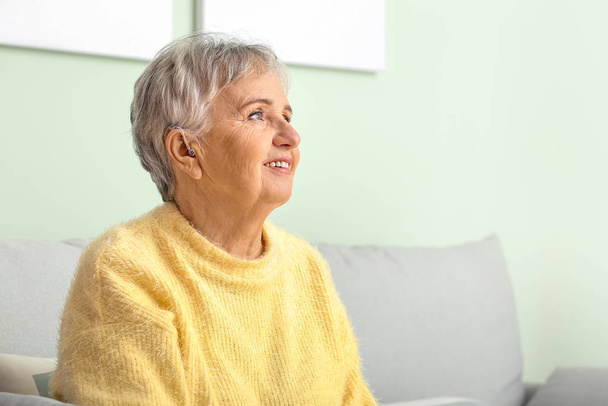 Idősebb nő hallókészülékkel otthon - Fotó, kép