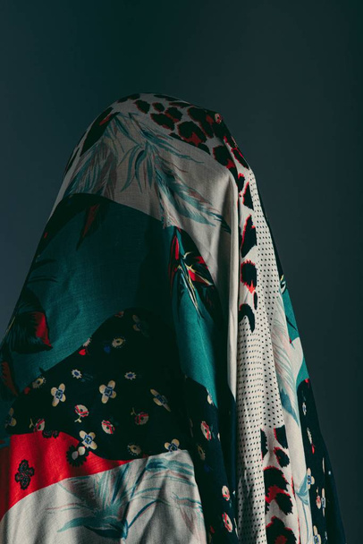 A beautiful vertical shot of a person covered in a scarf with different patterns - Foto, Imagen