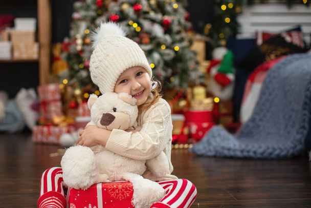 cute girl child 4 years in a light sweater and hat with pumponch - Foto, Imagen