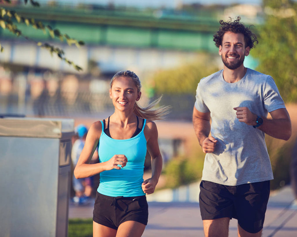 Donna moderna e uomo che fanno jogging / esercizio in un ambiente urbano
  - Foto, immagini