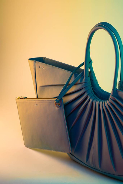 A vertical shot of a minimalistic trendy purse on a colorful background - Foto, Bild