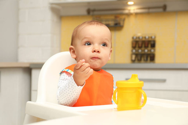 Cute little baby eating cookie at home - Foto, imagen
