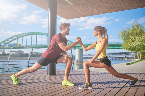 Современные женщина и мужчина упражнения в городской среде рядом с р
 - Фото, изображение