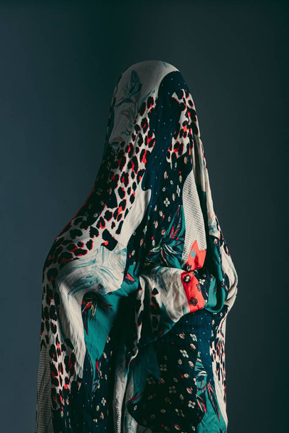 Beautiful vertical shot of a person covered in a scarf with different patterns - Photo, image