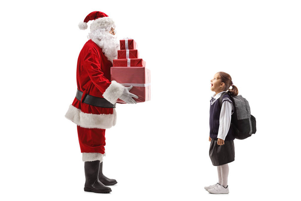 Santa Claus giving presents to a girl in a red dress - Foto, afbeelding