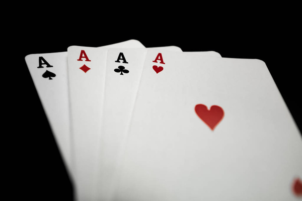 cuatro ases jugando a las cartas sobre fondo negro
 - Foto, imagen