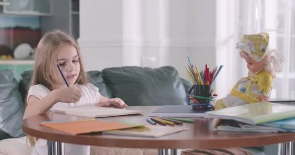 Little cute Caucasian girl doing math at home. Pretty child writing figures in exercise book and thinking. Intelligence, education, studying. Cinema 4k ProRes HQ. - Filmagem, Vídeo