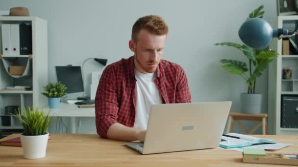 Tired ginger-haired guy working with computer in office feeling headache - Filmagem, Vídeo