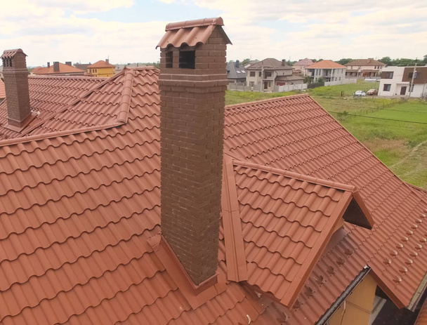 オレンジの金属製の新しい屋根を持つ家。上からの眺め。カー - 写真・画像