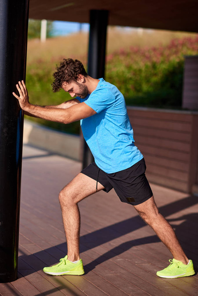 Man stretching and exercising in urban surroundings. - Fotó, kép