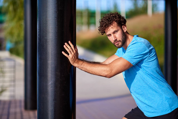 Man stretching and exercising in urban surroundings. - Photo, Image