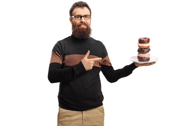 Bearded man holding a plate of donuts and pointing - Фото, зображення