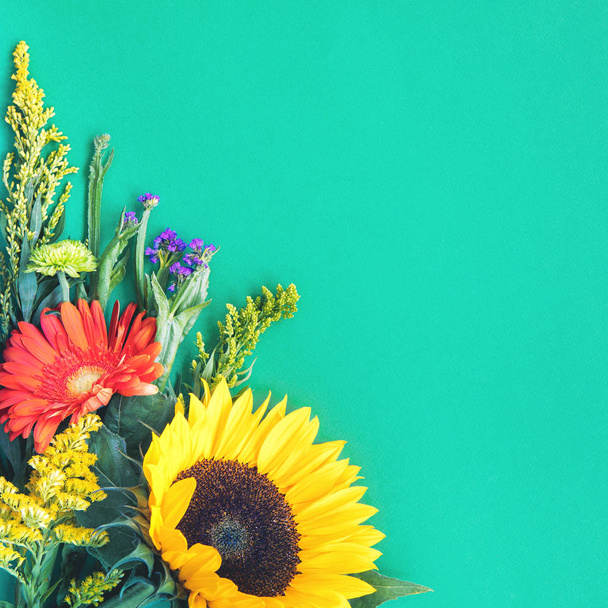 diferentes flores de verano de colores tumbados sobre fondo de menta
 - Foto, imagen