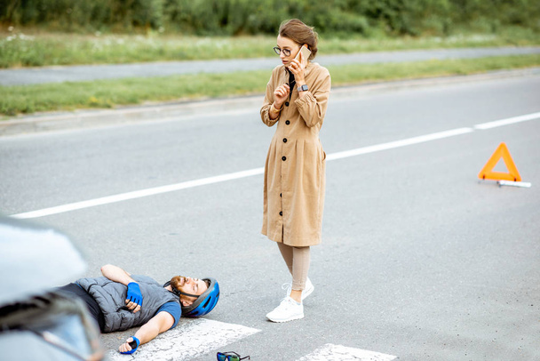 負傷したサイクリストと女性ドライバーと道路事故 - 写真・画像