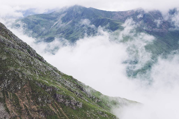 eine Landschaft aus Rauch, der aus den Bergen inmitten einer grünen Aussicht aufsteigt - Foto, Bild