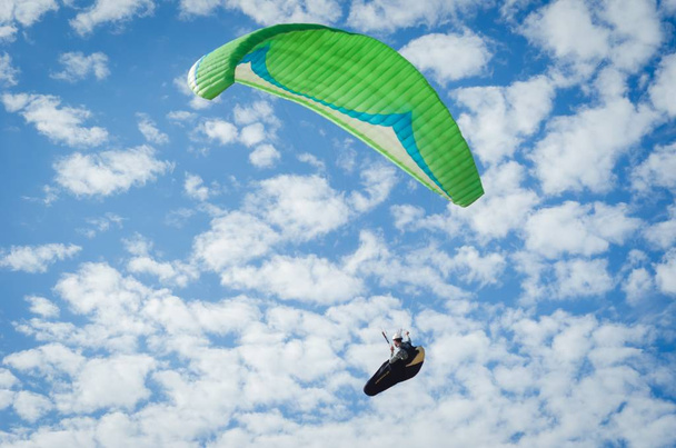 Low angle shot of a person paragliding in the sky - freedom concept - Fotó, kép