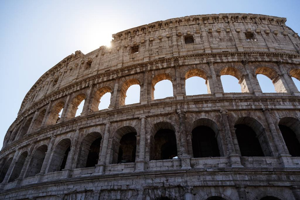 A low angle shot of the famous Colosseum in Rome, Italy under the bright sky - Foto, Bild