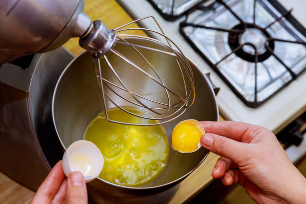 Une femme sépare le blanc d'oeuf du jaune pour faire un gâteau éponge
. - Photo, image