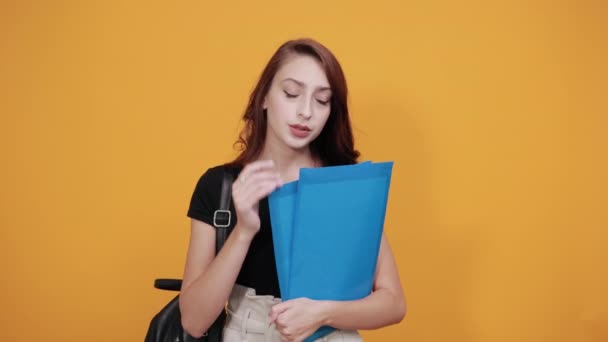 Attractive woman keeping blue folder, holding hand on head, headach - Séquence, vidéo