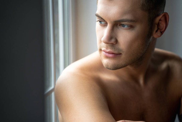 Close up of handsome man sitting near the window - Foto, immagini