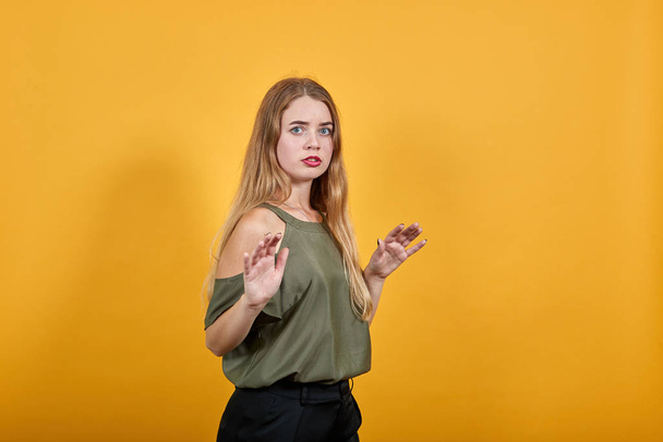 Woman over orange wall making unimportant gesture stop, looking directly - Fotografie, Obrázek