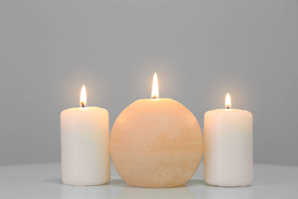 Сяючі свічки на білому столі
 - Фото, зображення