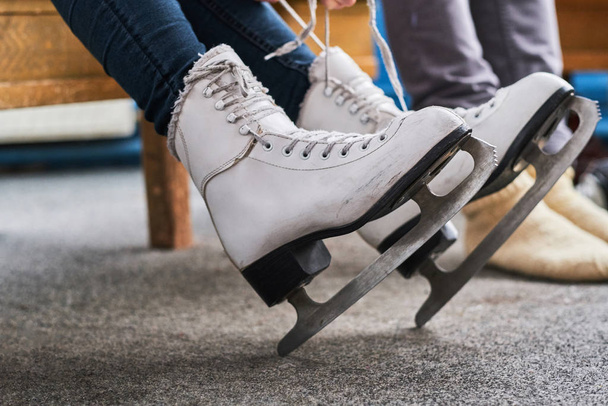 Young couple preparing to a skating - 写真・画像