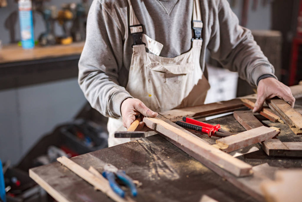 Menuisier travaillant sur un vieux bois dans un atelier vintage rétro
. - Photo, image