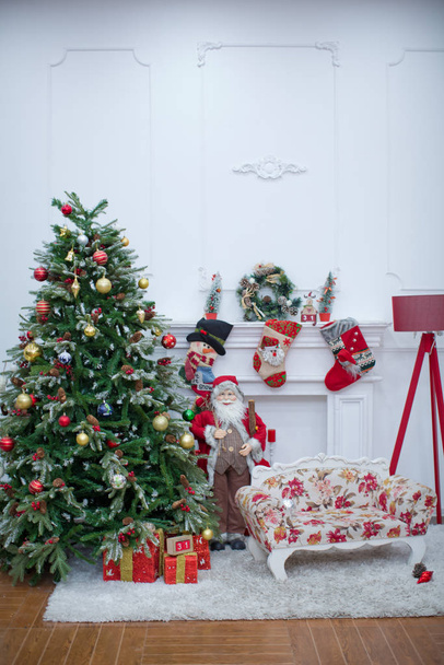 Maria Kerst interieur met nieuwjaar pime boom versierd. Kerstmis rode fauteuil en geschenken. Kerstman Klaus. Kerstfotozone versierd. Kerstmis met versierde een boom met Gelukkig Nieuwjaar op blauw . - Foto, afbeelding