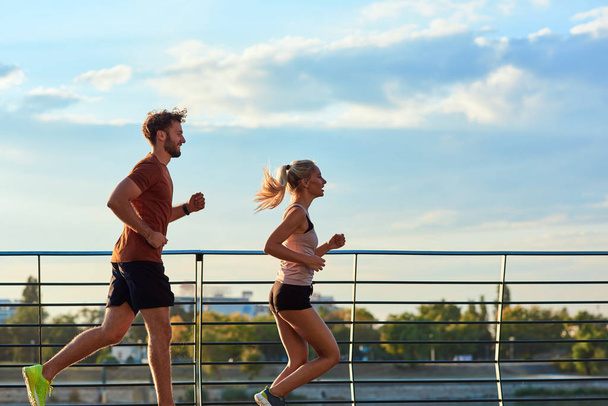 Сучасна жінка і чоловік бігають / займаються спортом в міському середовищі
  - Фото, зображення