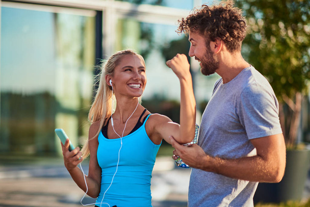 Modern woman and man jogging / exercising in urban surroundings  - Photo, Image