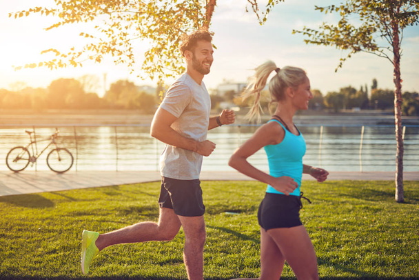 Modern woman and man jogging / exercising in urban surroundings  - 写真・画像