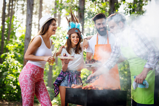 Group of friends having outdoor barbecue party and fun together - Foto, imagen