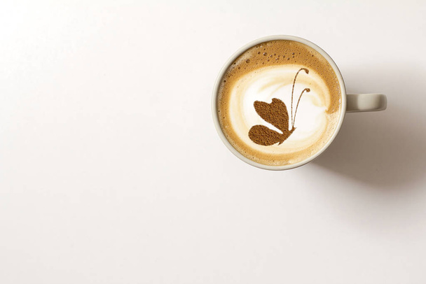 Top view of hot coffee with butterfly cappuccino latte art  - Foto, afbeelding