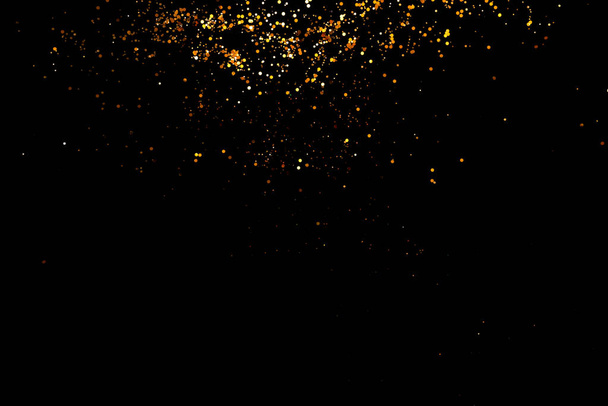 Golden sparkles on black background - Foto, Bild