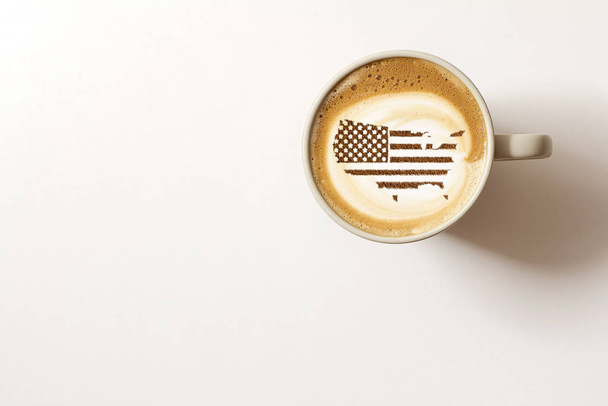 Flag of the United States of America in the form of territorial borders on a cappuccino coffee cup close-up - Fotografie, Obrázek