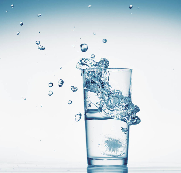 un verre d'eau avec éclaboussures de glaçons tombants, fond blanc, objet isolé
 - Photo, image
