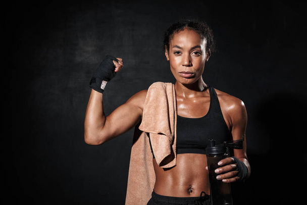 Image of african american woman in boxing hand wraps showing her bicep - Valokuva, kuva